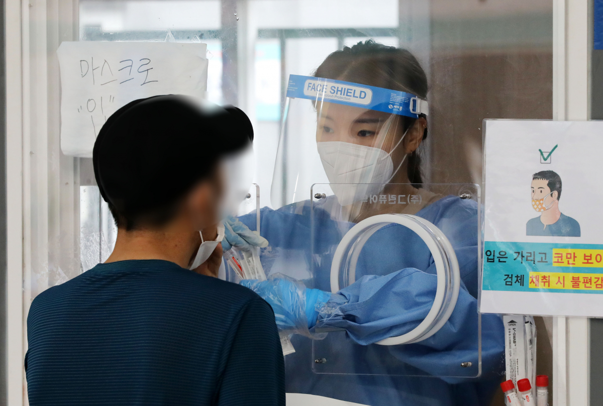 ▲코로나19 신규 확진자가 711명으로 집계된 5일 오전 서울 중구 서울역광장에 마련된 코로나19 중구임시선별검사소에서 의료진이 검체 채취를 하고 있다. (뉴시스)