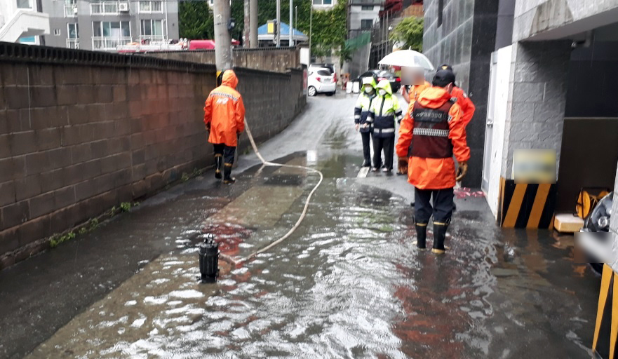 ▲부산지역에 호우·강풍특보가 발효된 6일 동래구의 한 골목이 침수돼 소방대원이 배수를 지원하고 있다. (뉴시스)
