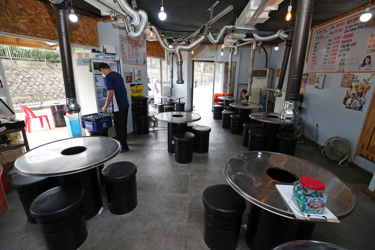 ▲수도권의 사회적 거리두기 4단계 적용을 하루 앞둔 11일 오후 서울 시내의 한 고깃집에서 식당 주인이 영업을 준비하고 있다. (연합뉴스)