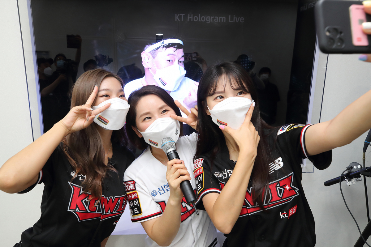 ▲KT 관계자들이 수원 KT 위즈파크내 마련된 28GHz 5G체험관에서 kt wiz 김주일 응원단장과의 실시간 양방향 홀로그램 팬미팅 서비스를 소개하고 있다.  (사진제공=KT)