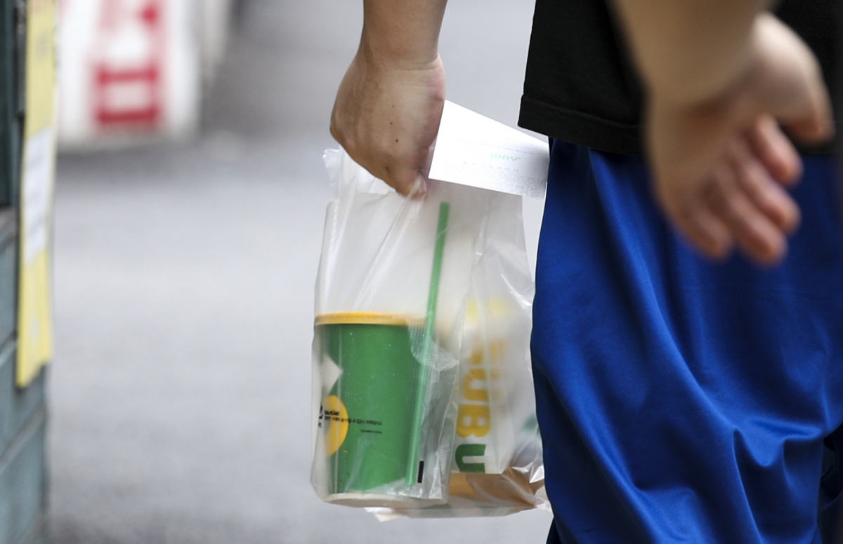 ▲수도권 사회적 거리두기 4단계 시행 첫날인 12일 오후 서울 시내 식당가에서 한 시민이 음식을 포장해가고 있다. (뉴시스)