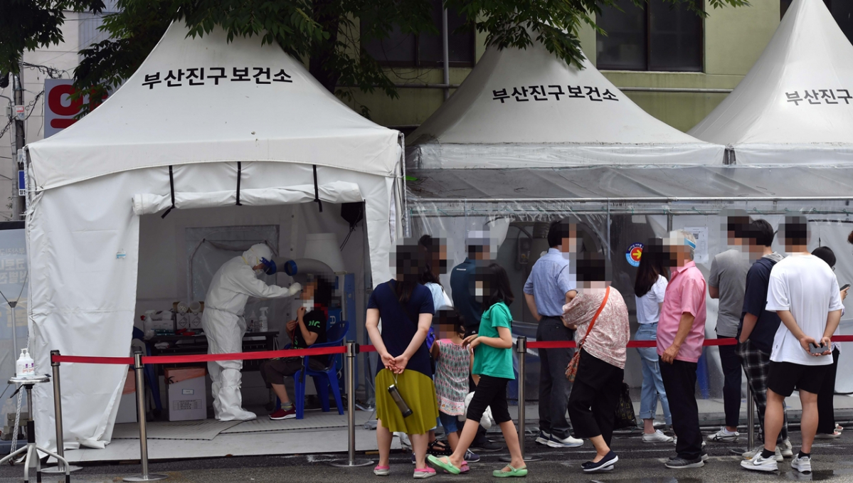 ▲13일 부산 부산진구보건소 선별진료소를 찾은 시민들이 코로나19 진단검사 검체 채취를 위해 길게 줄을 선 채 자신의 차례를 기다리고 있다.  (뉴시스)