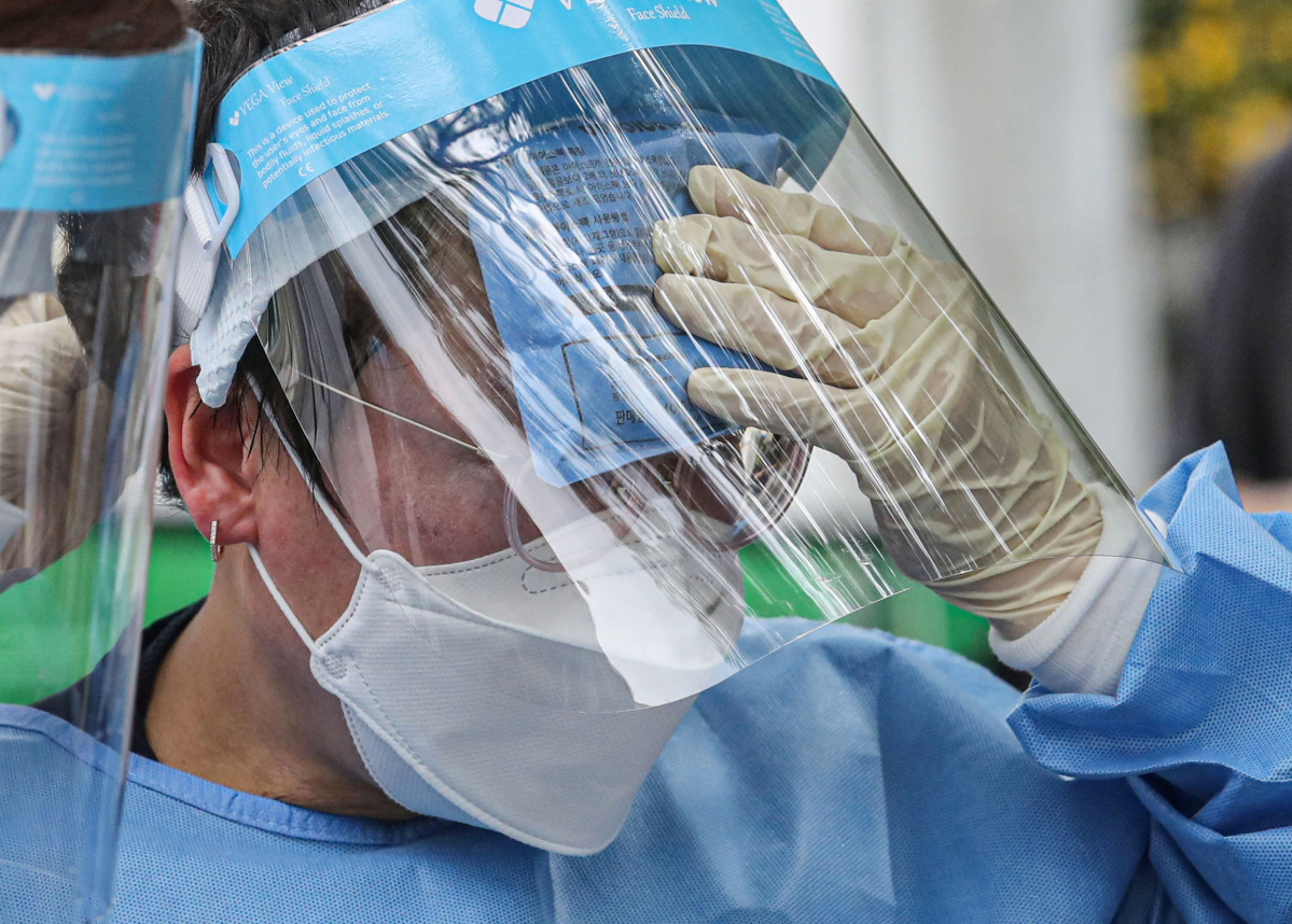 ▲서울을 비롯한 전국 대부분 지역에 폭염특보가 내려진 13일 오후 서울 동작구청 주차장에 마련된 임시선별검사소에서 의료진이 아이스팩으로 더위를 식히고 있다. (뉴시스)