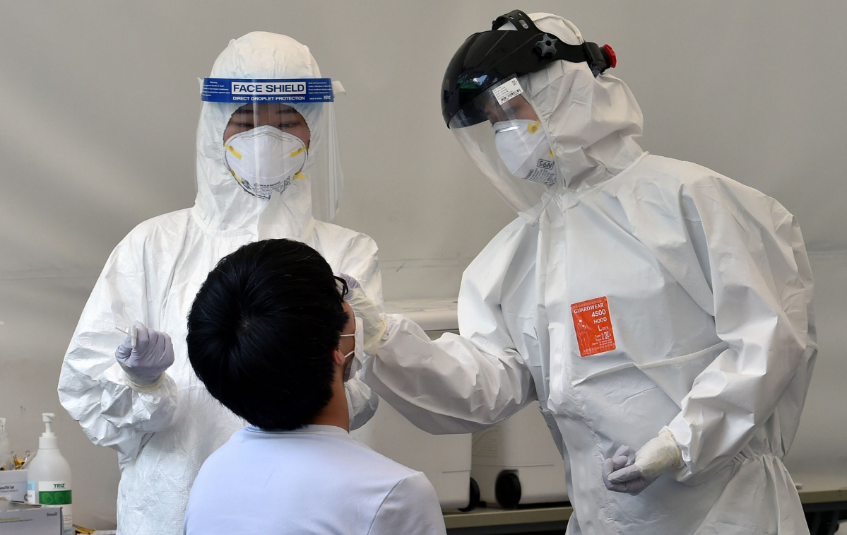 ▲대구지역 코로나19 확진자가 52명으로 집계된 14일 오후 대구 수성구 보건소 코로나19 선별진료소에서 의료진이 검체 채취를 하고 있다. (뉴시스)