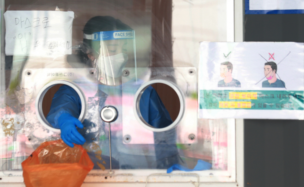 ▲18일 서울 중구 서울역 광장에 마련된 신종 코로나바이러스 감염증(코로나19) 임시 선별검사소에서 의료진이 다음 검사를 위한 소독을 마치고 잠시 대기하고 있다. (연합뉴스)