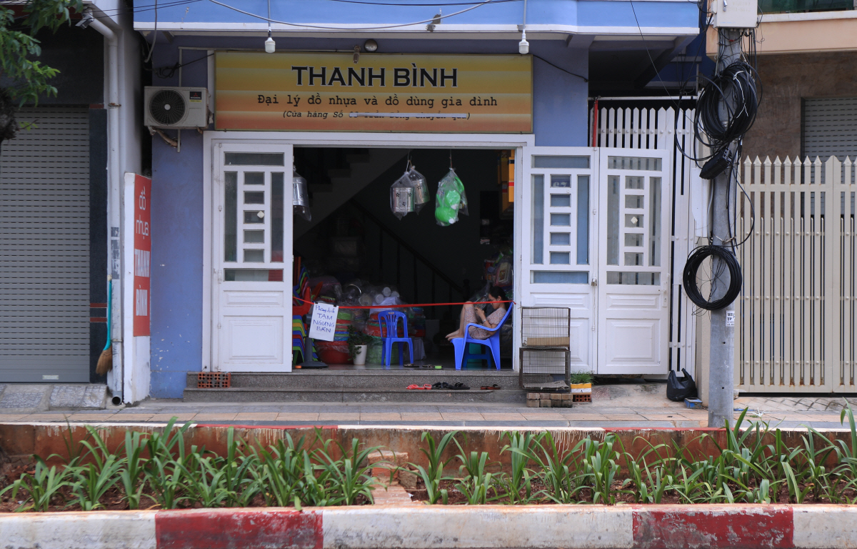 ▲19일 베트남 붕따우에서 한 여성이 신종 코로나바이러스 감염증(코로나19) 봉쇄로 영업을 하지 않는 상점 안에 앉아 있다. 붕따우/AP뉴시스