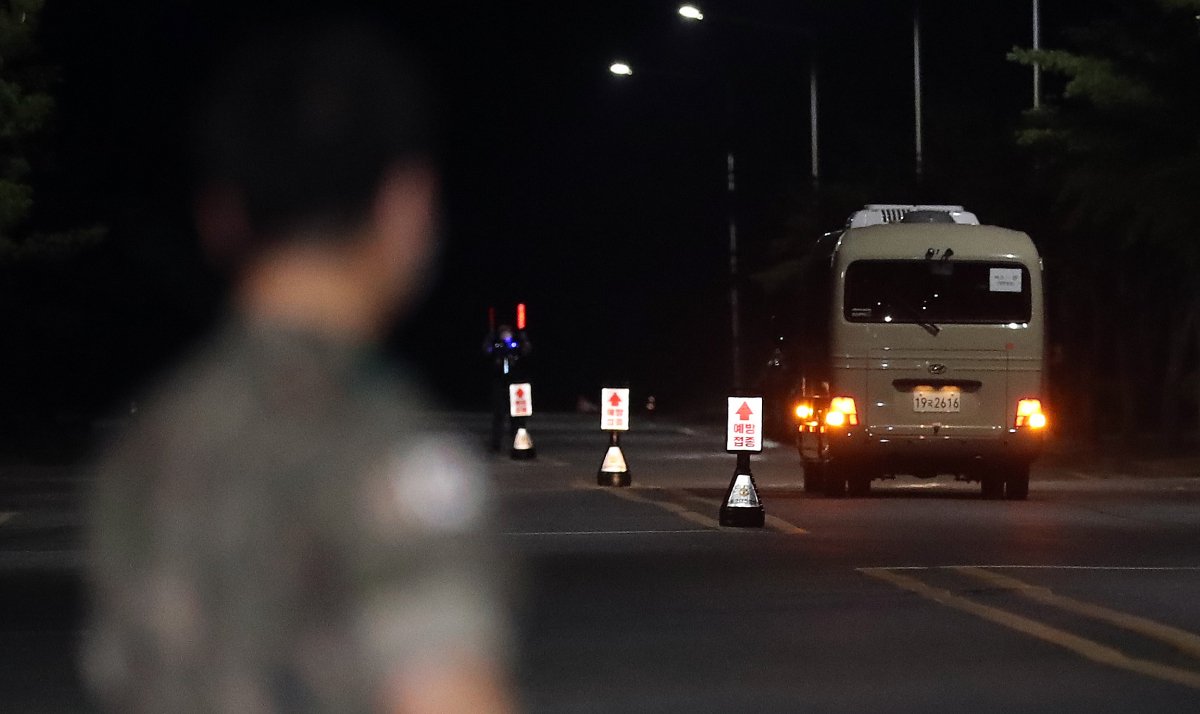 ▲해외 파병 중 코로나19에 집단감염돼 귀국한 청해부대 제34진 장병들이 탑승한 버스가 20일 밤 대전시 유성구 국군대전병원에 도착하고 있다. (뉴시스)