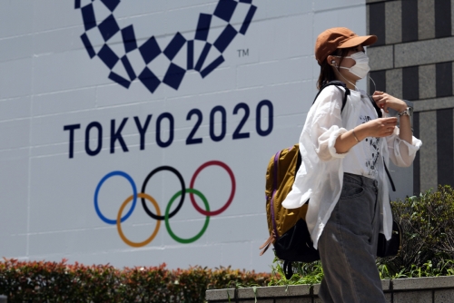 ▲2020 도쿄올림픽 현수막 앞을 마스크를 쓴 시민이 지나가고 있다.  (도쿄/AP연합뉴스)