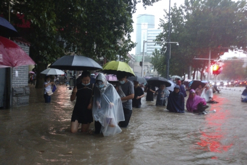 ▲중국 허난성 정저우시에 폭우가 내려 사람들이 물이 가득찬 길거리를 걷고 있다. 정저우/AP연합뉴스
