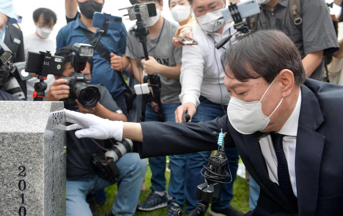 ▲윤석열 전 검찰총장이 지난 7월 6일 오전 대전 유성구 국립대전현충원 천안함46용사 묘역을 참배한 뒤 전사자의 묘비를 어루만지고 있다. (공동취재사진단)