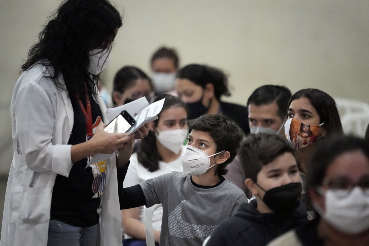 ▲파라과이 아순시온의 한 스포츠센터에서 23일(현지시간) 의료진이 화이자 백신 접종에 앞서 한 어린이의 건강 상태를 묻고 있다. 아순시온/AP연합뉴스