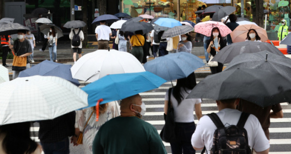▲전국에 비가 내리며 장마가 시작된 3일 오후 서울 마포구 홍대입구역 인근에서 시민들이 우산을 쓰고 길을 건너고 있다.  (연합뉴스)