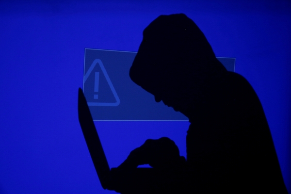 ▲한 남성이 느낌표가 있는 파란색 스크린에 투영된 노트북을 들고 있다. 로이터연합뉴스
