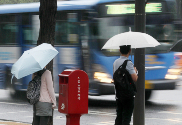 ▲4일 오전 서울 중구 한국프레스센터 앞에서 우산을 쓴 시민들이 버스를 기다리고 있다. (뉴시스)