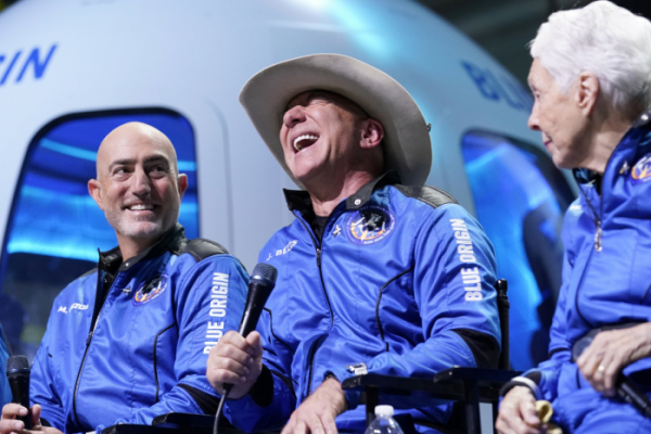 ▲제프 베이조스(가운데) 아마존 이사회 이장이 우주 여행을 다녀온 뒤 텍사스 벤혼 인근 발사장에 마련된 기자회견장에서 활짝 웃고 있다. ( AP/뉴시스)