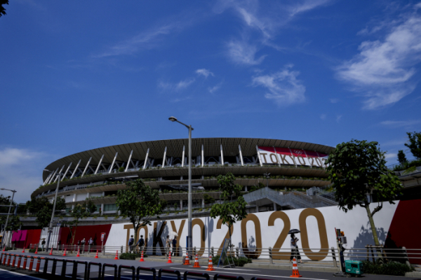 ▲도쿄올림픽·패럴림픽 개막식이 열리는 국립경기장 앞을 마스크를 쓴 사람들이 지나가고 있다. ( 도쿄/AP연합뉴스)
