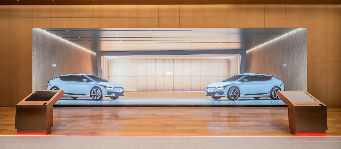 ▲강서 플래그십 스토어에 설치된 대형 미디어 월과 그 앞에서 ‘3D 컨피규레이터’를 통해 차량을 3D 이미지로 체험하고 있다.  (사진제공=기아)