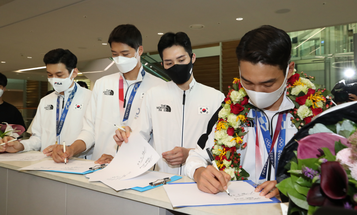 ▲2020 도쿄올림픽 펜싱 사브르 남자 단체전에서 금메달을 딴 대한민국 국가대표팀 김정환(오른쪽부터), 김준호, 오상욱, 구본길 선수가 7월 29일 오후 인천국제공항 제2여객터미널을 통해 귀국, 사인을 하고 있다. (뉴시스)