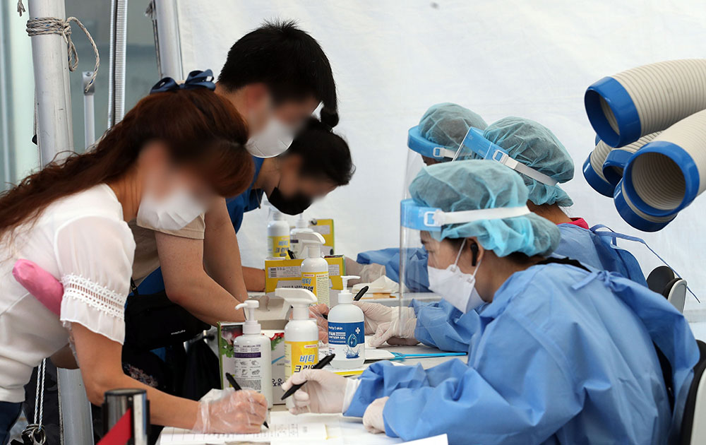 ▲코로나19 신규 확진자가 2223명으로 코로나19 사태 이후 역대 최다를 기록한 11일 오전 서울 양천구의회 주차장 임시선별검사소에서 시민들이 검사를 받기위해 문진표를 작성하고 있다.  (뉴시스)