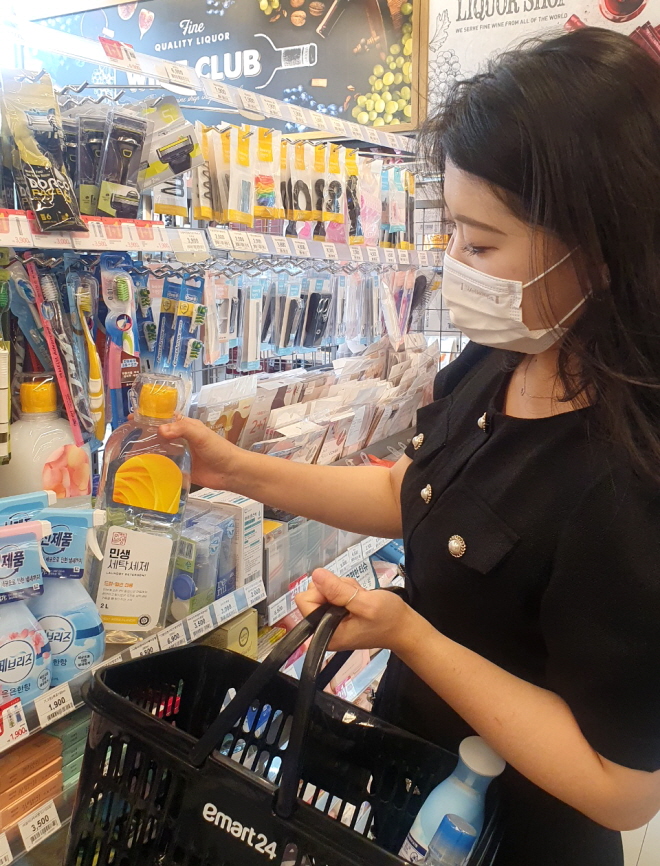 ▲고객이 이마트24에서 초저가 민생세제 등 생필품을 구매하고 있다. (사진제공=이마트24)