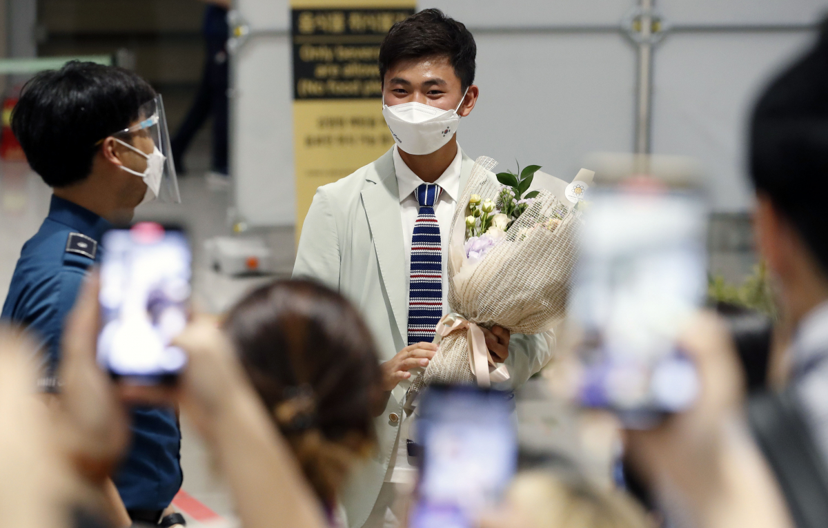 ▲대한민국 양궁 대표팀 김제덕이 1일 오후 2020 도쿄올림픽을 일정을 마치고 인천국제공항을 통해 귀국해 꽃다발을 들고 있다.  (뉴시스)