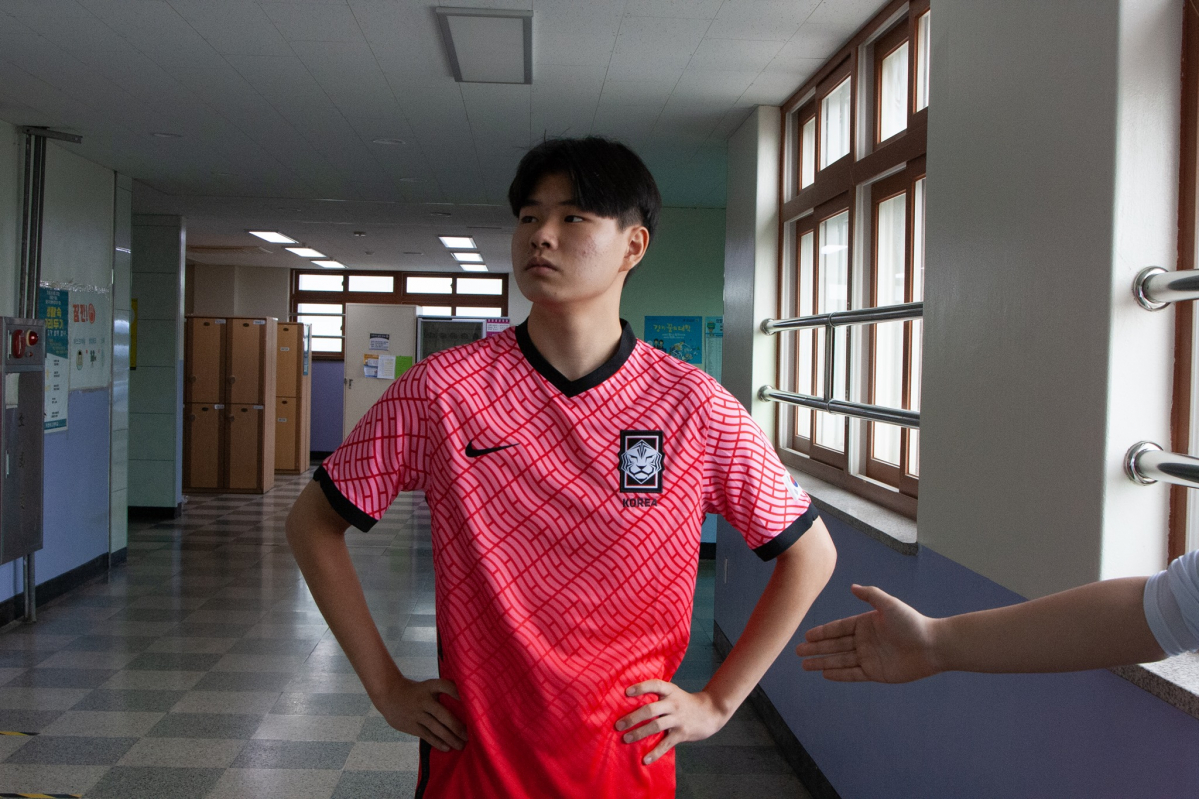 ▲의정부고등학교 학생이 축구 국가대표 공격수 이동경이 올림픽에서 팀 패배 뒤 상대 선수의 악수를 거절해 논란이 된 장면을 패러디 하고 있다.  (출처=의정부고등학교 학생자치회)