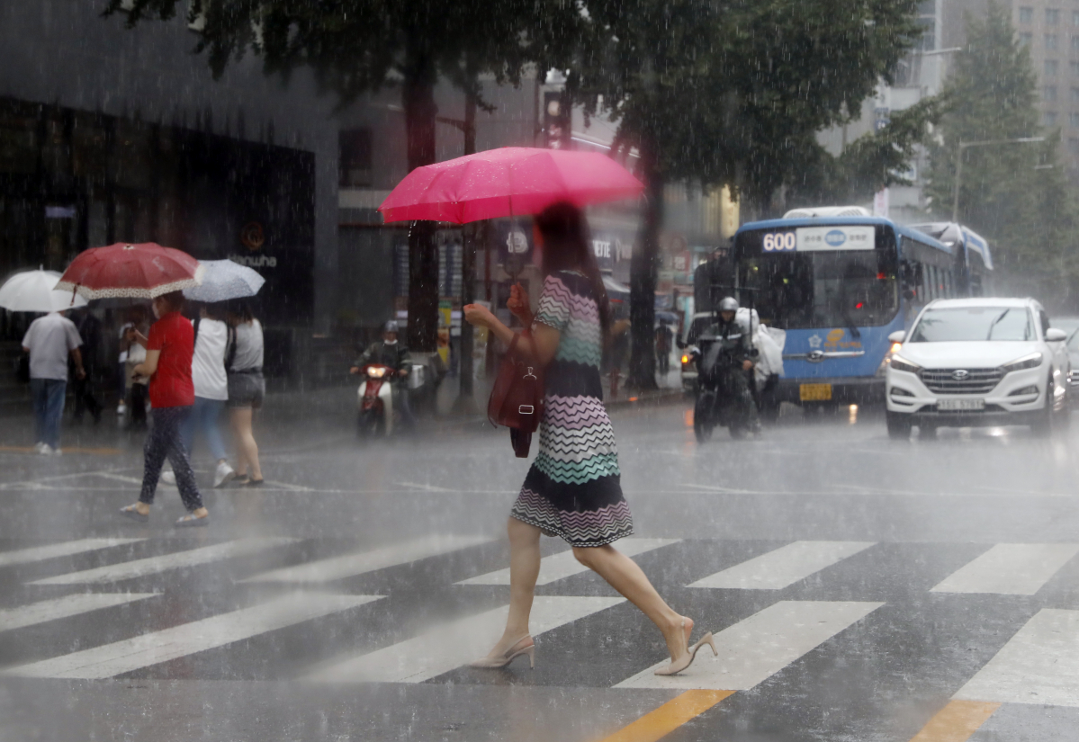 ▲서울지역에 폭우가 내리면서 서울 중구의 한 대형 빌딩 앞에서 우산을 쓴 시민이 발걸음을 재촉하고 있다. (뉴시스)