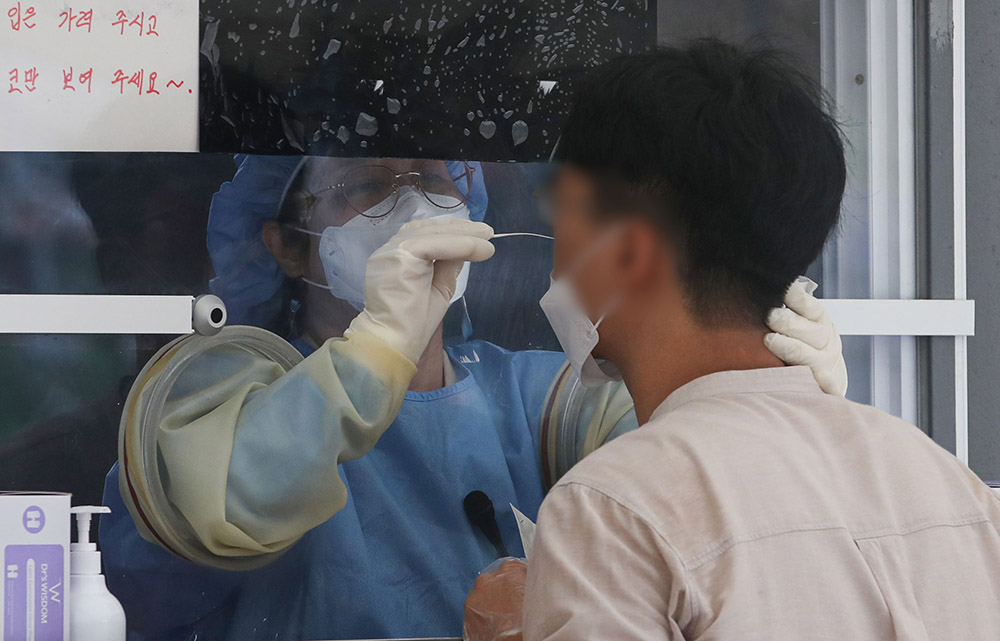 ▲코로나19 신규 확진자가 2155명으로 닷새 만에 2000명 대를 기록한 25일 오전 서울 중구 서울광장 임시선별검사소에서 의료진이 검체 채취를 하고 있다. (뉴시스)