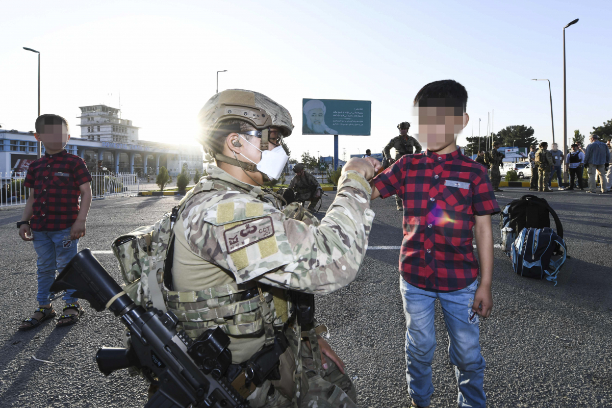 ▲공군 최정예 특수부대 요원인 공정통제사가 25일 아프가니스탄 카불공항에서 한국으로 이송될 아프간 현지 조력자 자녀와 인사하고 있다.  (연합뉴스)