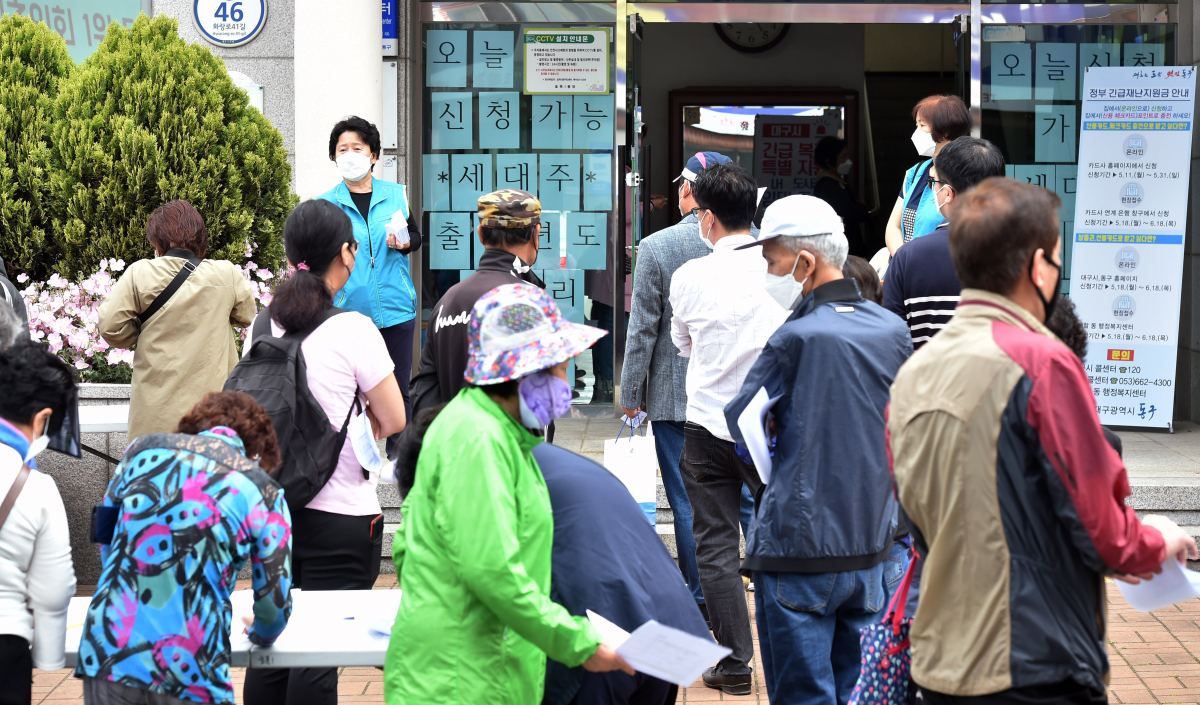 ▲2020년 5월 18일 대구 동구 효목1동 행정복지센터에서 시민들이 신종 코로나바이러스 감염증(코로나19) 대응을 위한 긴급재난지원금 오프라인 신청서 접수를 위해 줄을 서고 있다.  (뉴시스)