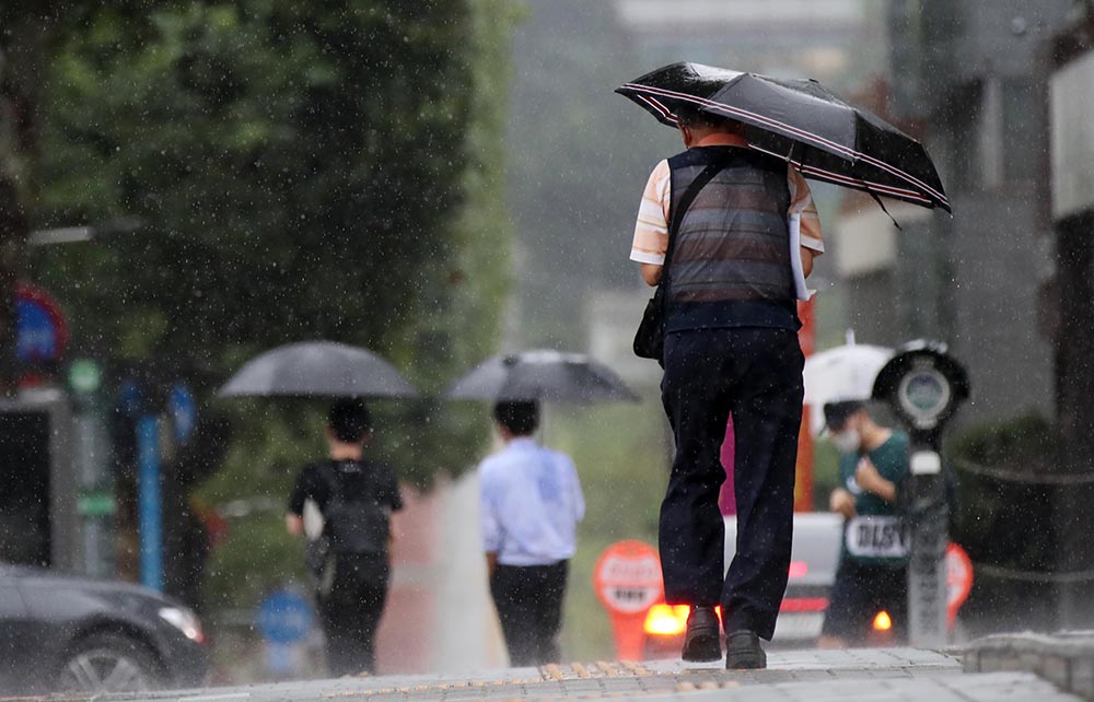 ▲서울 경기를 중심으로 굵은 비가 쏟아지고 있는 31일 오후 서울 서초구 인근 도로에서 시민들이 우산을 쓰고 지나가고 있다. (뉴시스)