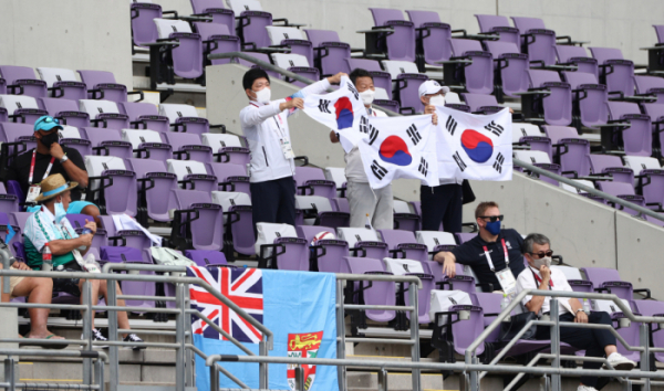 ▲지난달 26일 도쿄올림픽 7인제 럭비 조별리그 A조 한국과 뉴질랜드의 경기가 열린 일본 도쿄스타디움에 이용(왼쪽) 국민의 힘 의원과 최윤(왼쪽 두번째) 대한럭비회장 겸 도쿄올림픽 선수단 부단장이 태극기를 흔들며 응원을 하고 있다.  (연합뉴스)