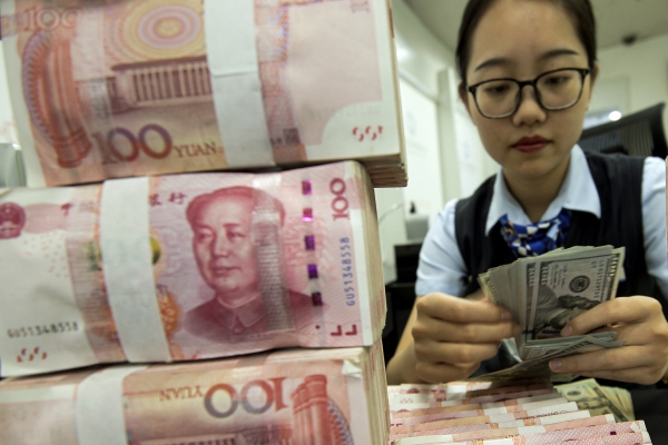 ▲중국 장쑤성 하이안의 한 은행에서 2019년 8월 6일 은행원이 위안화를 앞에 두고 달러를 세고 있다. 하이안/AP뉴시스
