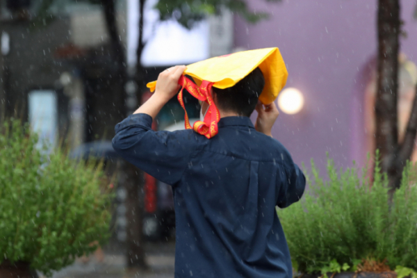▲서울 서대문구 신촌거리에서 8일 시민들이 비를 피하고 있다.  (뉴시스)