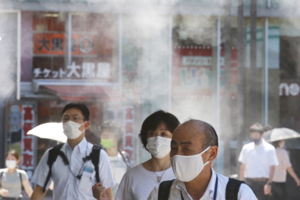 ▲ 일본 도쿄 시내에서 5일 마스크를 쓴 행인들이 분무기 아래를 지나가고 있다. 도쿄/AP연합뉴스

