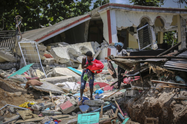 ▲15일(현지시간) 아이티 레카예의 한 주민이 강진으로 무너진 주택 잔해 사이에서 소지품 등을 찾고 있다. 레카이/AP뉴시스