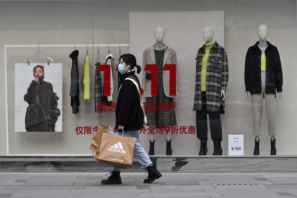▲지난해 11월 11일 광군제 당시 중국 베이징의 한 의류매장 앞을 행인이 지나가고 있다. 베이징/AP뉴시스
