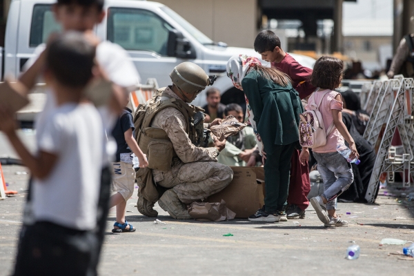 ▲아프가니스탄 카불 국제공항에서 21일(현지시간) 한 미국 해병대 요원이 어린이에게 전투식량을 건네고 있다. 카불/UPI연합뉴스 
