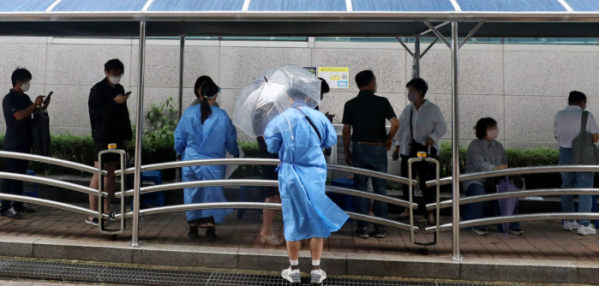 ▲24일 오후 서울 관악구보건소 선별진료소에서 의료진이 우산을 쓰고 시민들을 안내하고 있다. (뉴시스)