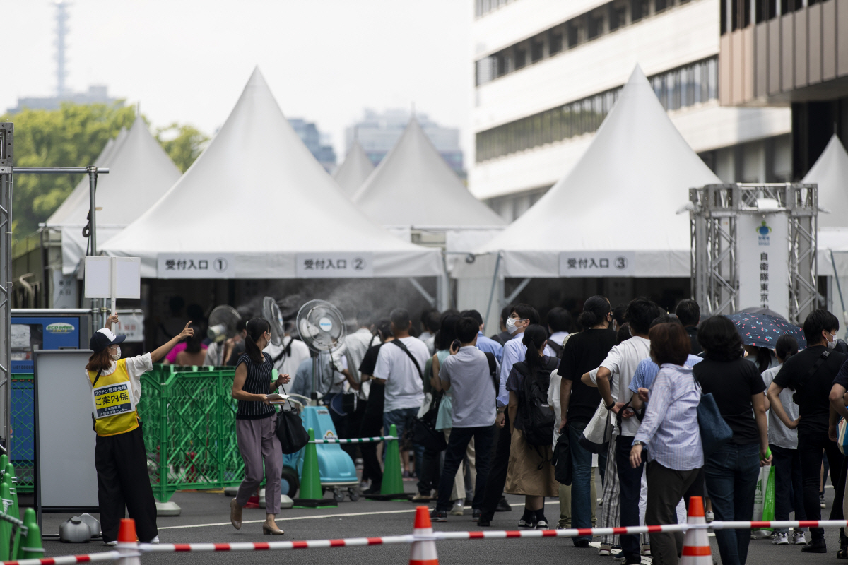 ▲지난달 26일 일본 도쿄에서 시민들이 화이자 백신 접종을 위한 등록 절차를 밟기 위해 줄지어 서 있다. 도쿄/AP연합뉴스