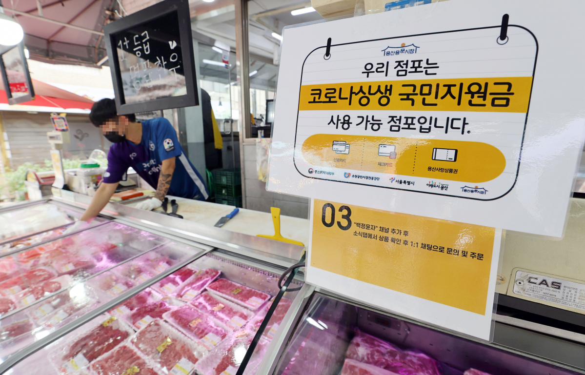 ▲코로나 상생 국민지원금(재난지원금) 지급 절차가 시작된 6일 서울 용산구 전통시장의 한 가게에 코로나 상생 국민지원금 사용 가능 안내 문구가 붙어있다. (연합뉴스)