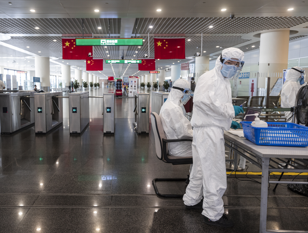 ▲중국 상하이 푸둥국제공항에서 8월 22일 보호복을 입은 직원들이 승객들을 체크하고 있다. 상하이/EPA연합뉴스 
