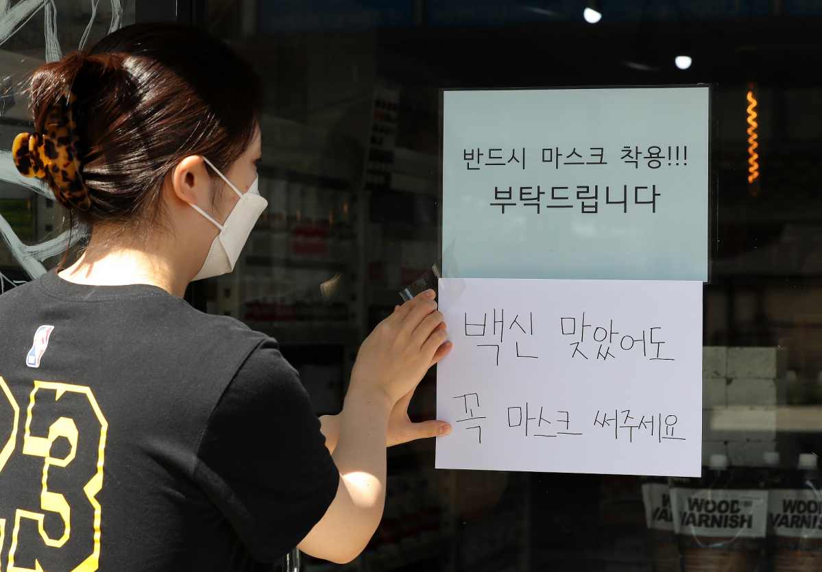 ▲백신 접종률이 높아지면서 '위드 코로나'가 화두로 떠오르는 9일 오후 서울시내 한 상가에 백신 접종 후에도 마스크 착용을 권고하는 안내문이 붙어있다. (뉴시스)