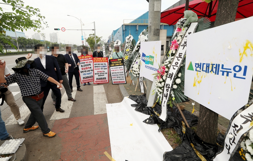 ▲두산인프라코어 소액주주모임 회원들이 10일 오전 인천시 동구 두산인프라코어 앞에서 경영진과 인수자인 현대제뉴인을 규탄했다. (사진 = 연합뉴스)