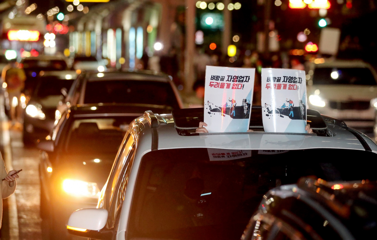 ▲전국자영업자비대위 회원들이 9일 새벽 서울 영등포구 여의대로에서 진행된 코로나19로 인한 고강도 사회적 거리두기 연장에 반발하는 전국동시차량시위에서 정부 방역지침을 규탄하는 손피켓을 들고 있다.  (뉴시스)