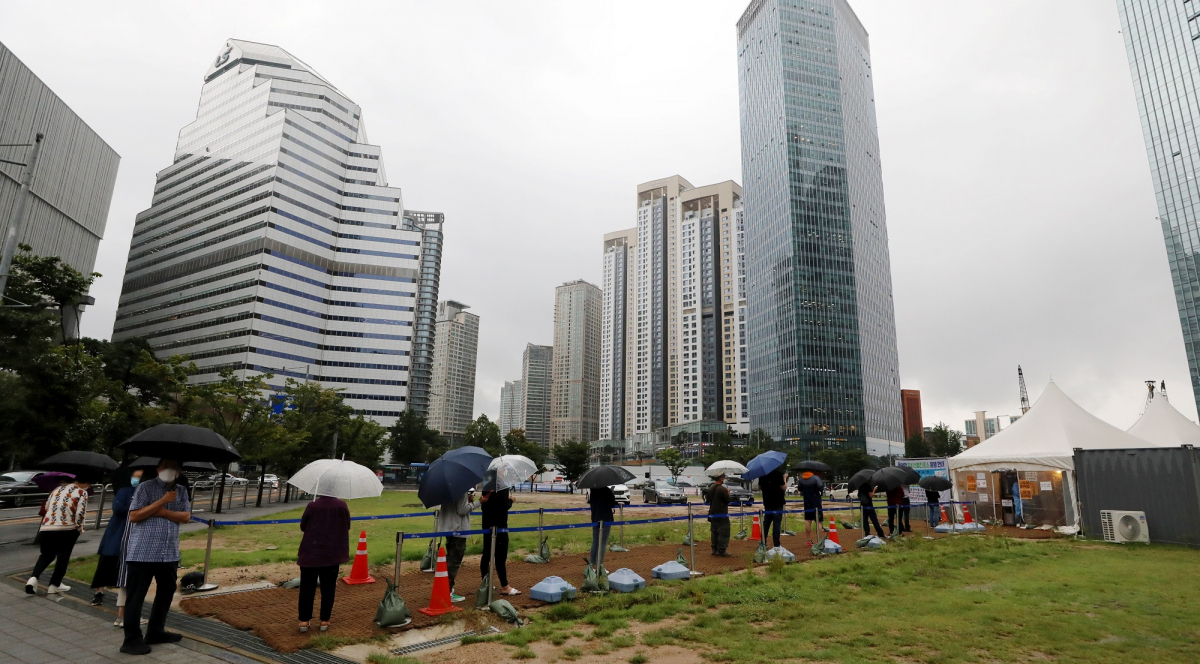 ▲7일 오전 서울 용산역에 마련된 임시선별진료소에서 우산을 쓴 시민들이 코로나19 검사를 받기 위해 길게 줄지어 서 있다.  (뉴시스)