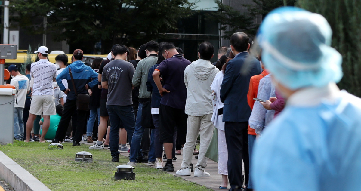 ▲수도권을 중심으로 한 코로나19 확산세가 이어진 27일 오전 서울 송파구보건소 선별진료소에는 코로나 검사를 받으려는 시민들이 길게 줄 지어 서 있다.  (뉴시스)