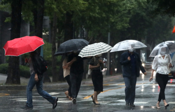 ▲가을 장마로 인한 많은 비가 내리고 있는 서울 종로구 한 도로에서 시민들이 퇴근길 우산을 들고 발걸음을 재촉하고 있다. (뉴시스)