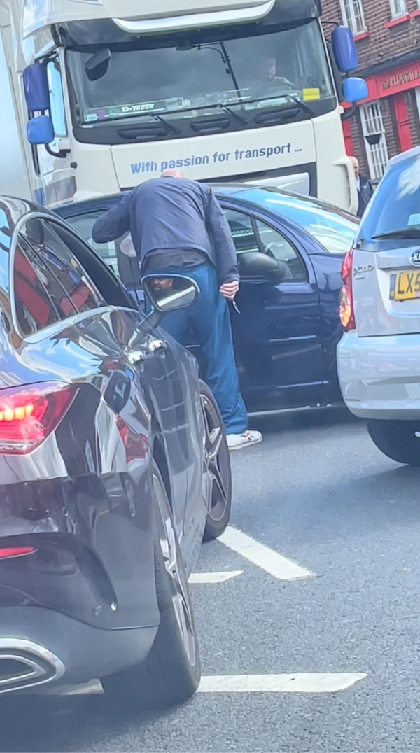 ▲영국 런던에서 27일(현지시간) 한 남성이 주유소 줄을 끼어드는 차량에 다가가 칼로 위협하고 있다. 런던/로이터연합뉴스
