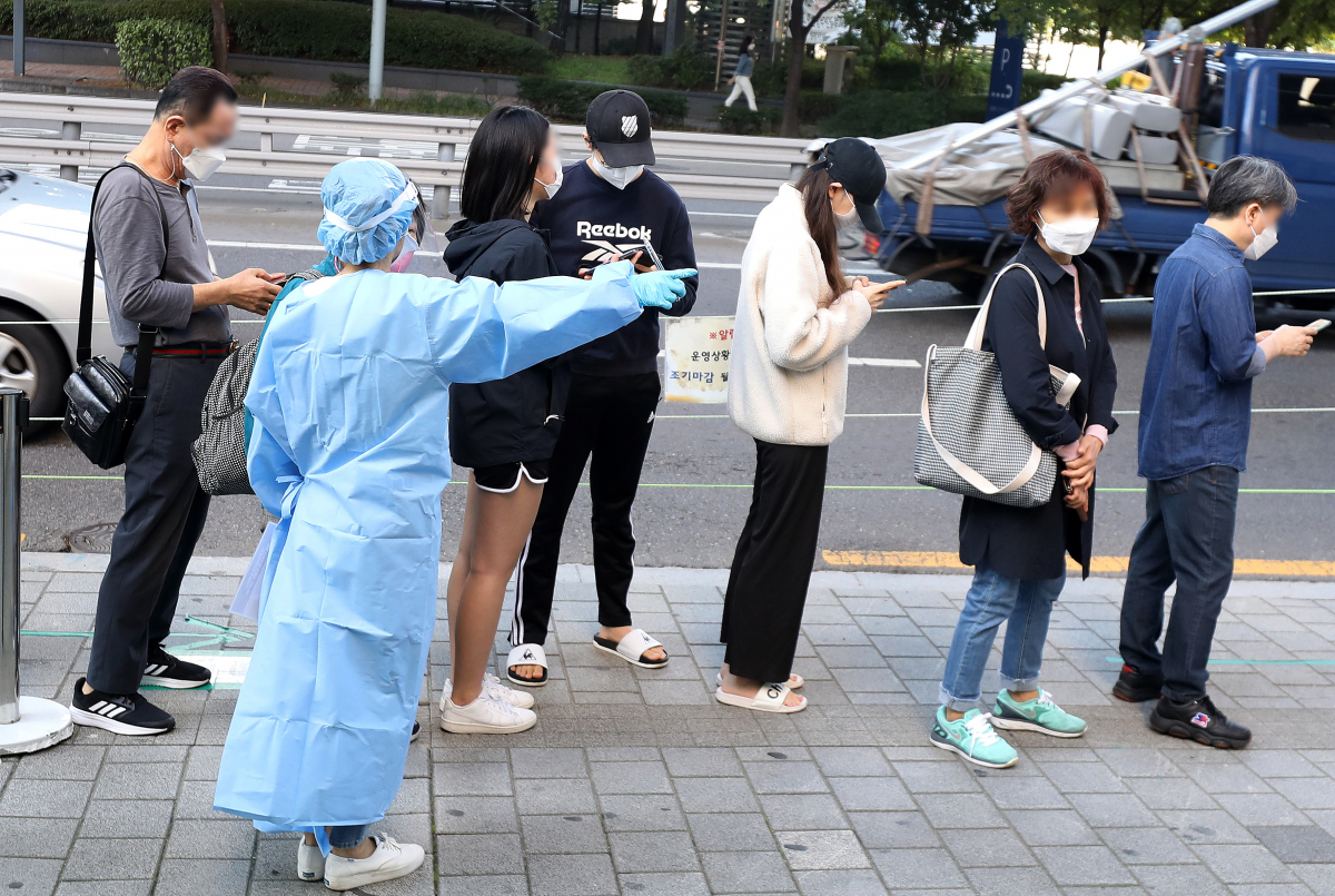 ▲코로나19 신규 확진자가 1584명으로 집계된 13일 오전 서울 성북구보건소 선별진료소에서 의료진이 시민들을 안내하고 있다.  (뉴시스)